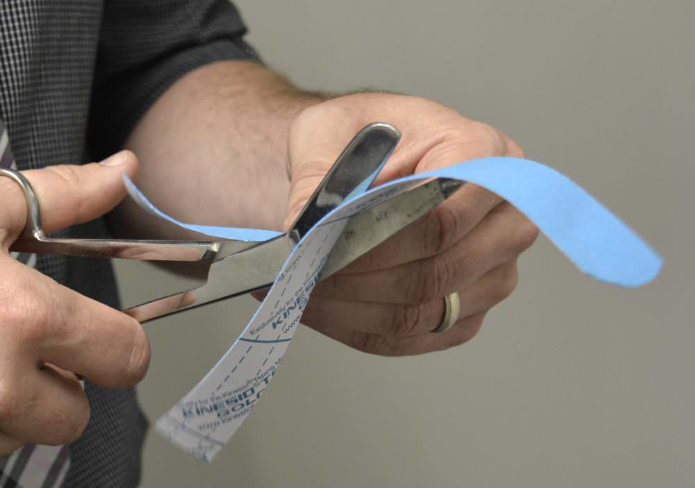 Image of Dr French cutting Kinesio Tape
