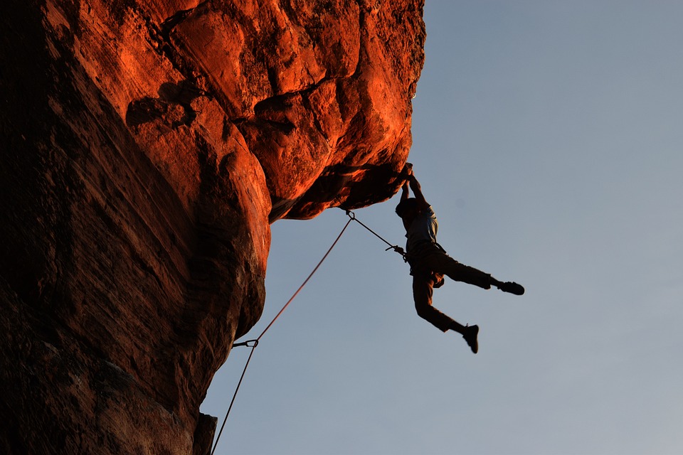 rock climber hinging by his hands